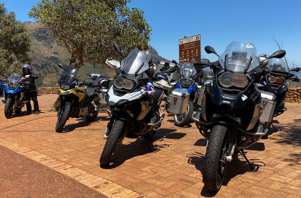 A group of motorbikes parked on a roadside.