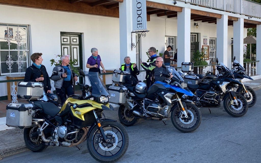 The group have a beer and a chat whilst standing next to their bikes.