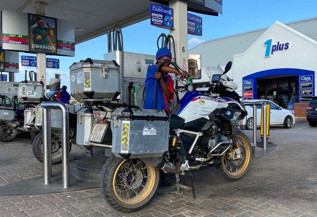 A man fills up one of the bikes with gas.