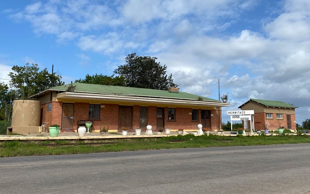 A pair of small, seemingly closed buildings on the side of the road.