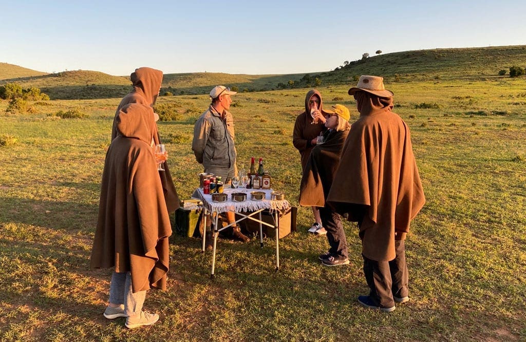 Turning back 5 The group take a food and drink break in the middle of a field as the sun sets.