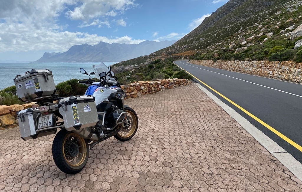 One of the bikes parked on the side of the road with a scenic view in the background.