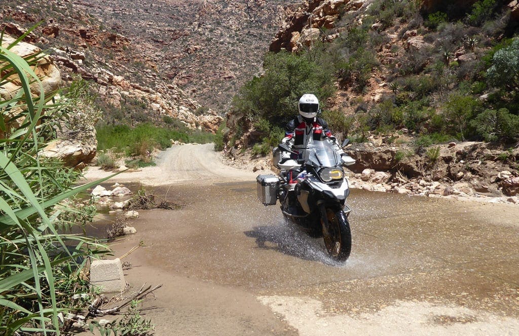 One of the bikers riding over a ford.