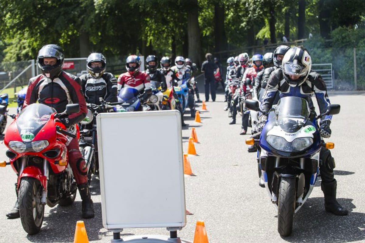 Motorcyclists on Susuki motorbikes lined up behind eachother.