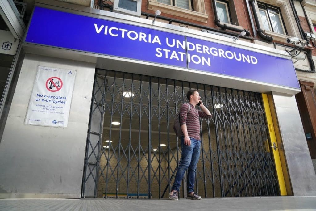 A person standing outside the closed Victoria Underground station.