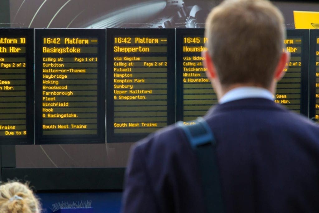 Commuter checking the digital timetables at Waterloo train station