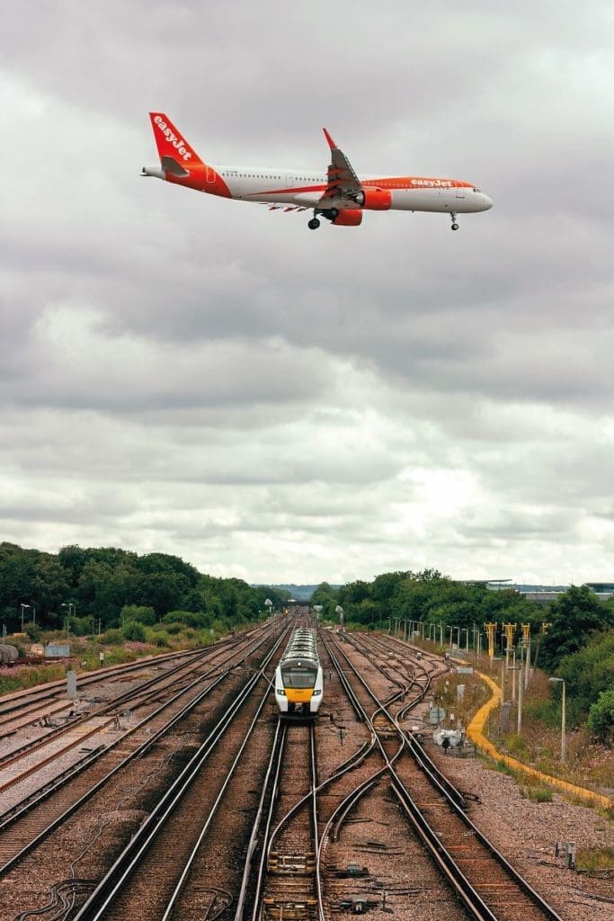 A train and plane cross paths at Gatwick Airport in August 2022