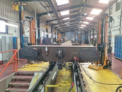 Inside single road wagon shed where a pair of flat wagons are under maintenance