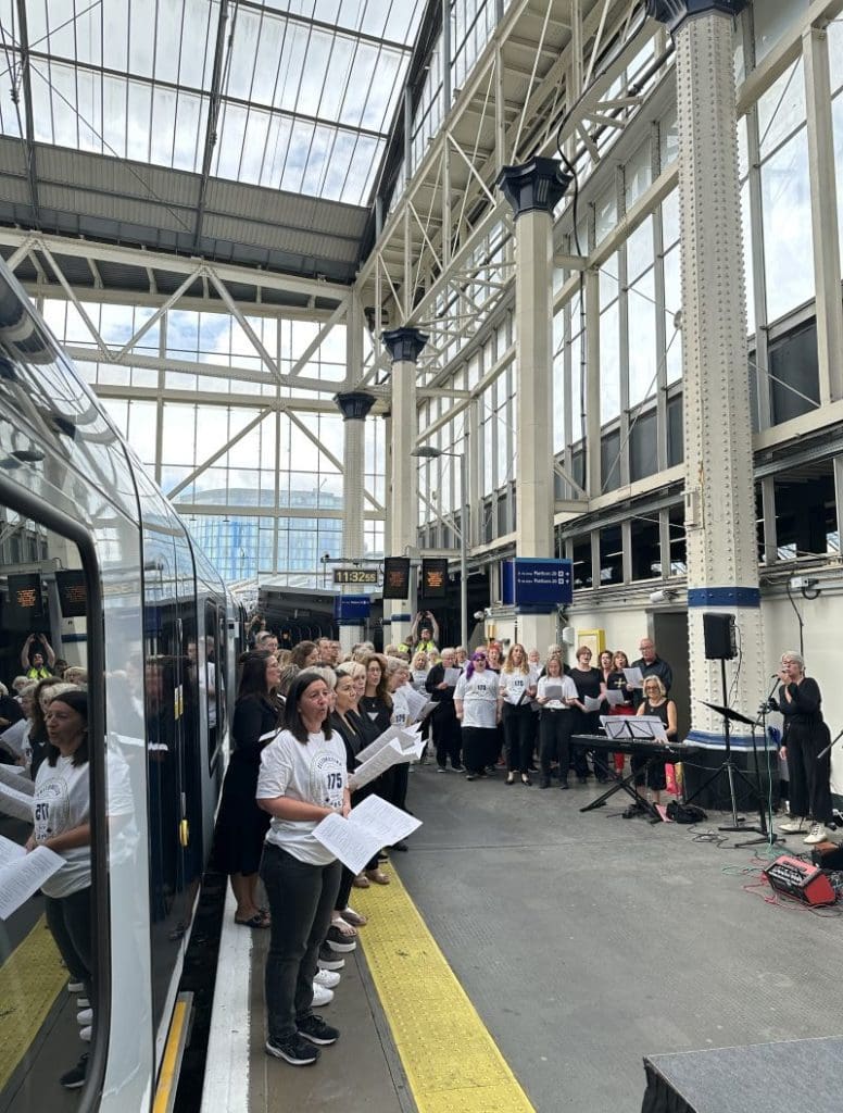 A choir of railway staff stand on a platform at Waterloo station as they perform 