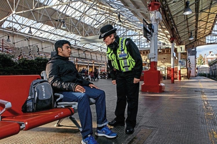 BTP Officer talking to teen boy on railway platform