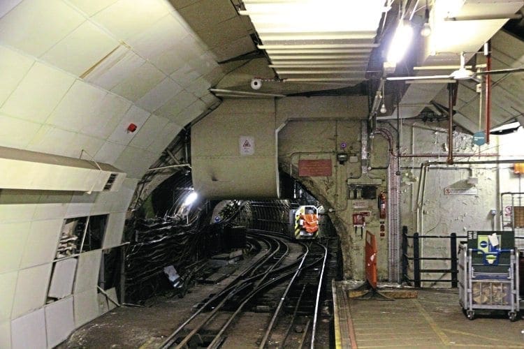 A February 2016 tunnel view with a contractor's loco in the distance. One of the Mail Rail ‘Mini York’ containers is on the platform  the right.