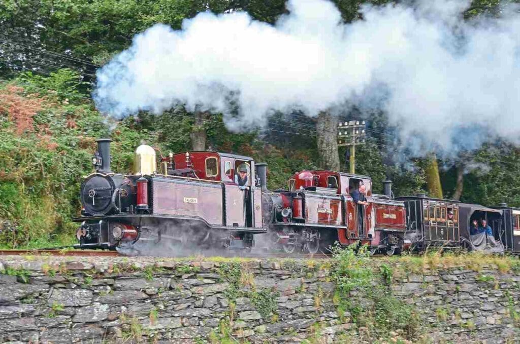 New-build single Fairlie Taliesin and Merddin Emrys, the oldest of the operational original double Fairlies on the Ffestiniog Railway, double-heading a Victorian train at Bron Madoc. CHRIS PARRY/Ff&WHR