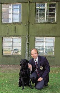 The editor with his black labrador Gibson outside of the former office (top right window) of Wg Cdr Guy Gibson VC DSO* DFC* at RAF Scampton. Mervyn Hallam