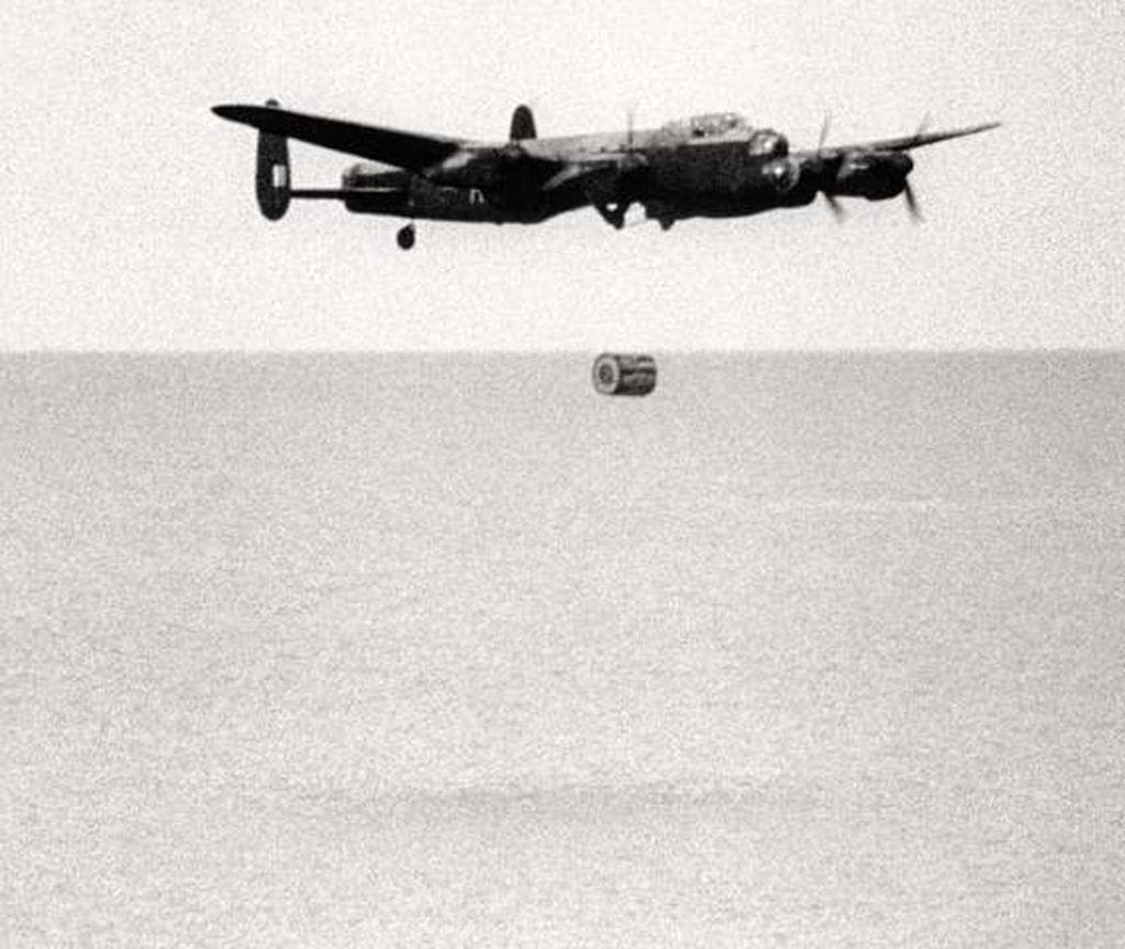Film still of a 617 Squadron Lancaster B.III (Special) practice dropping an Upkeep at Reculver on 12 May 1943. The bomb is caught just falling from the Lancaster which can be seen beginning to climb. IWM FLM2340