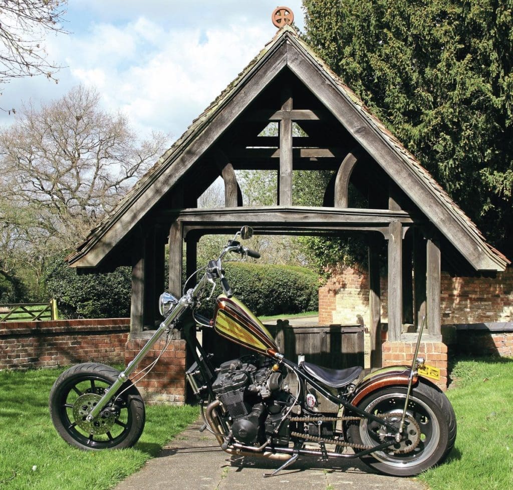 The bike in front of a lychgate. 