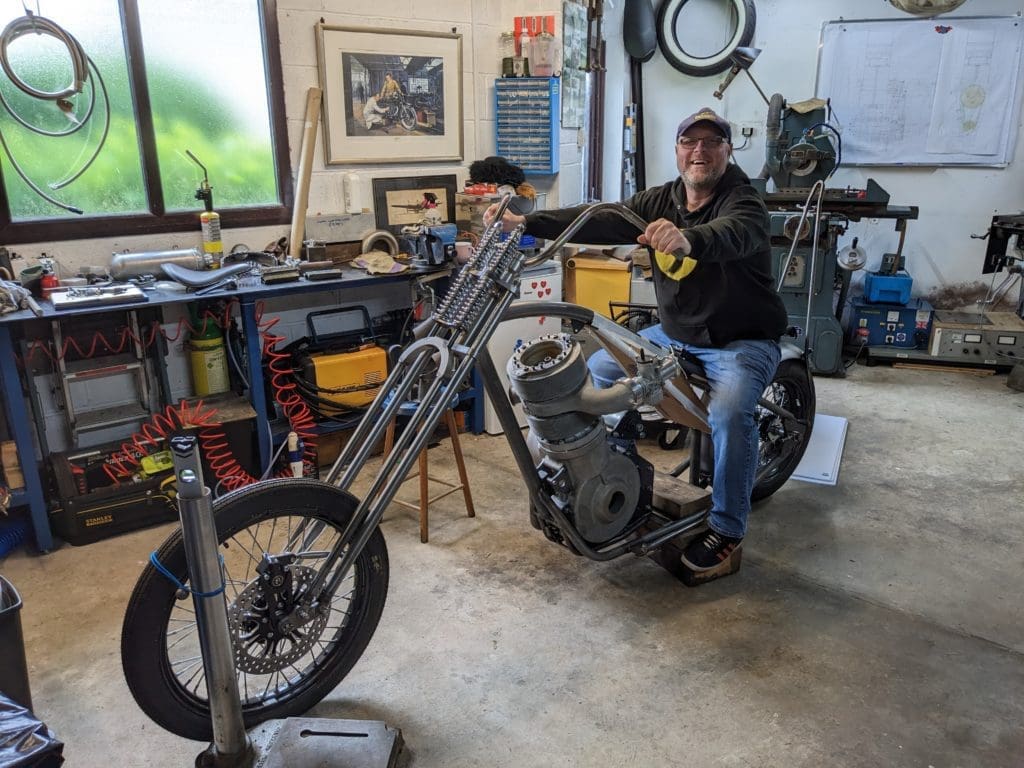 Bart sits on his in-progress custom bike with Bristol Hercules engine and smiles at the camera