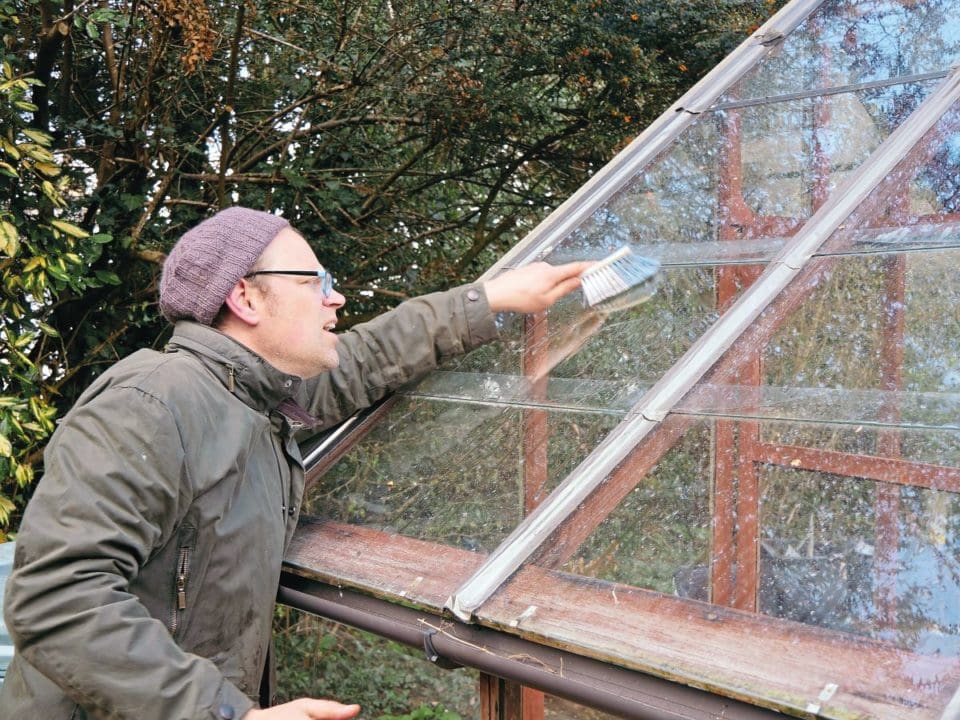 Ben cleans his greenhouse in January