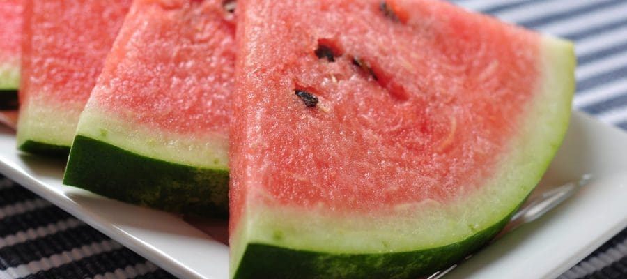 Sliced watermelon on a plate, on a striped tablecloth