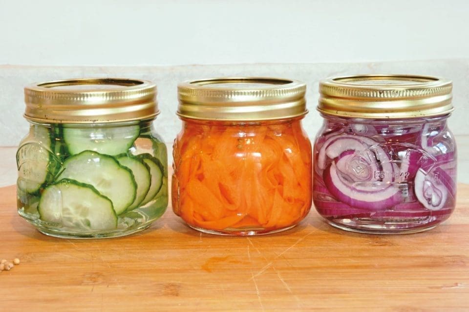 Jars of preserved and pickled cucumbers, carrots and onions