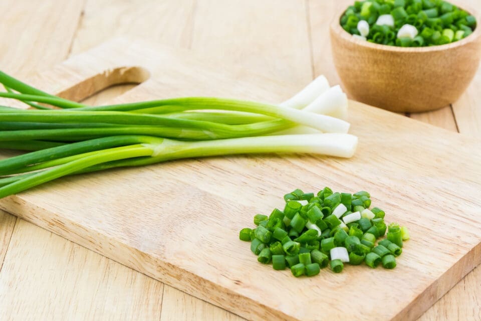 Spring onions on a chopping board