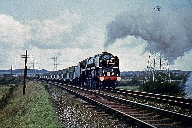 Wirral steam finale; BR Standard 9F 2-10-0 No. 92203 (now preserved) heads past Prenton golf course with the last steam-hauled iron ore train from Bidston dock to John Summers’ steelworks at Shotton on November 6, 1967. COLOUR-RAIL.COM 381167