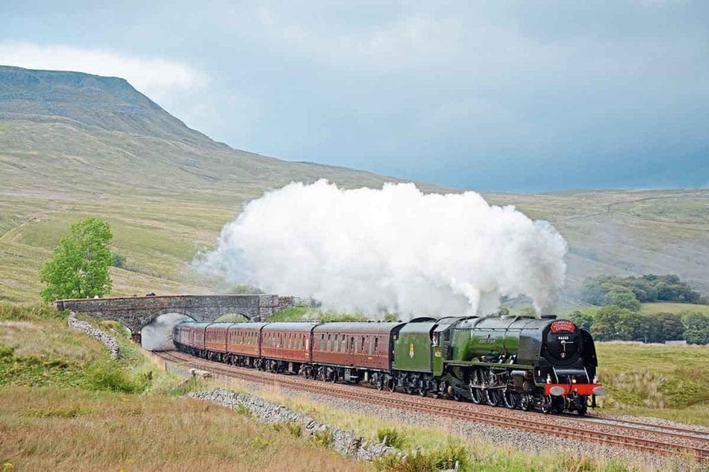 BR green-liveried Princess Coronation Pacific No. 46233 Duchess of Sutherland tops Ais Gill Summit with the Railway Touring Company's 'Cumbrian Mountain Express'. Photo: Mortons Archive