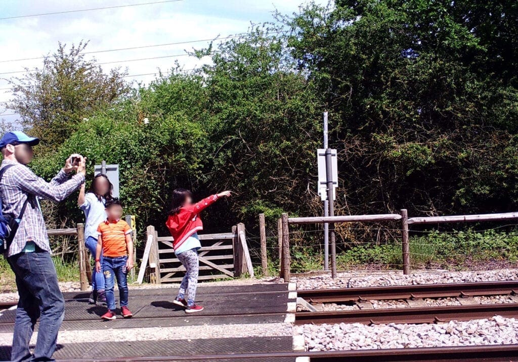 Family taking photos on a level crossing.