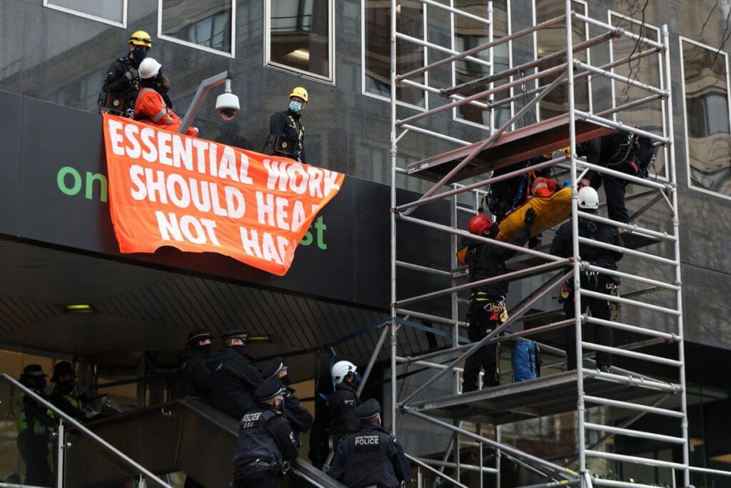 Extinction Rebellion protesters are removed by police officers after they climbed onto the canopy of the HS2 offices on Eversholt Street in London. 
