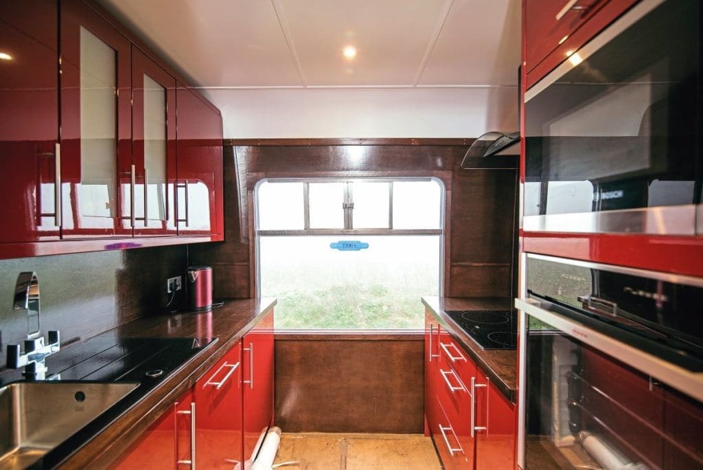 A kitchen with red counters and black counter tops.