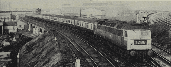 Photo: R. L. Sturges
Mystery tour train from Llanelli to Canterbury West passing Factory Junction, by Stewart’s Lane motive power depot, south-east of Clapham Junction, in February 1972, behind class “47” No. 1666, “Odin”.