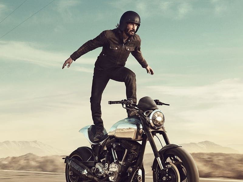Keanu Reeves takes the mickey out of himself in bike-surfing, bike flying and hand-in-fire videos. We like them.