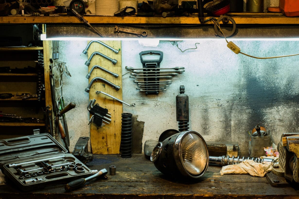 Motorcycle parts and tools on the desktop in the garage