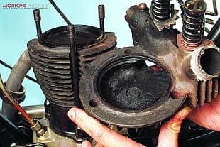 Motorcycle cylinder head being removed from vintage barrel