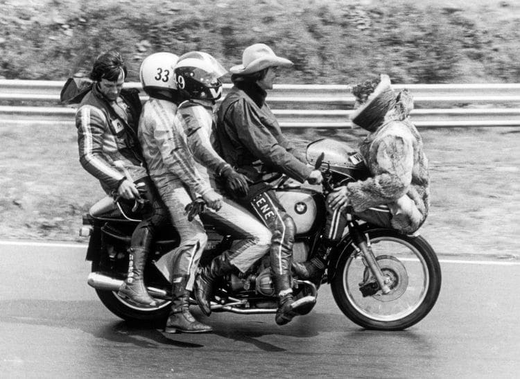Five men on a motorcycle June 1974, Phil Read perched on the front mudguard, Barry Sheen has hold of the handle bars, behind him Pete Williams then Paul Smart and right at the back is Gianfranco Bonera.