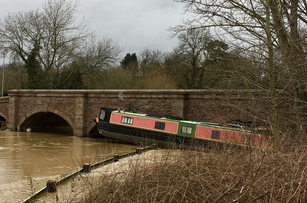 Capsized narrow boat on the edge of the River Soar.