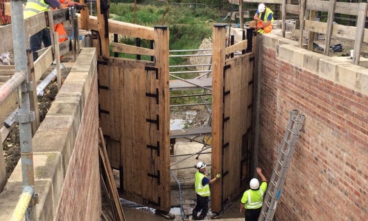 Grantham canal volunteers make up for lost time by lifting new lock gates into historic lock
