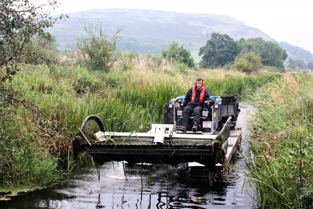 James Ormrod is at the controls of a Truxor amphibious tractor, which each year clears away hundreds of tonnes of unwanted weeds and reeds from the waterway.