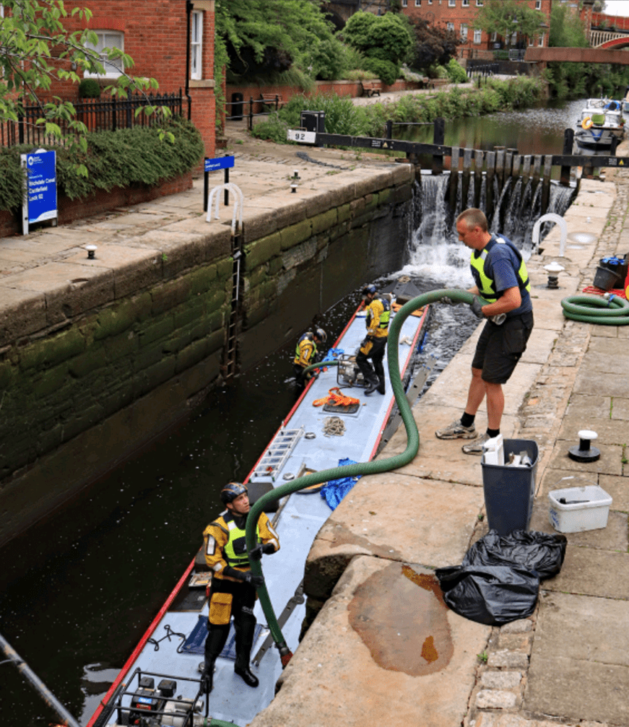 Pipework being passed down into Lock 92 on the Rochdale Canal to pump out water from the sunken narrowboat