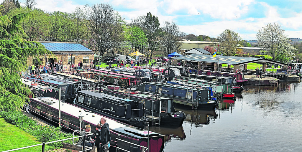 Cw 7971 South Pennine Boat Club headquarters at Mirfield 18.4.2022.  The club house and moorings of the South Pennine Boat Club in Mirfield, West Yorkshire.   This has been the base of the boat club since 1985 when they took over an old boat yard. Since then they have developed the site clearing out the basin, building and extending the club house and re-commissioning and building a roof over the dry dock.   On Easter Monday in April 2022 they held a open day for visitors to come and have a look what they have to offer, learn about boating and to watch performances of the “the unique and world famous handspike dance”.  Colin Wareing 25.4.2022  Image Cw 7971 copyright Colin Wareing of Colin and Carole’s Creations  www.thewoolboat.co.uk www.colinandcarolescreations.co.uk  E-mail colinandcarolescreations@yahoo.co.uk  Phone no 07931 356204   Location  South Pennine Boat Club, Wood Lane, Mirfield, West Yorkshire. England.