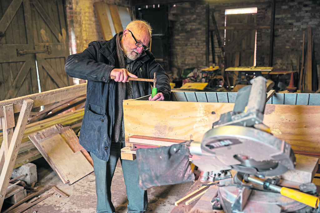 The oldest volunteer, 82-year-old Dave Moore, making a mould for a concrete window lintel.