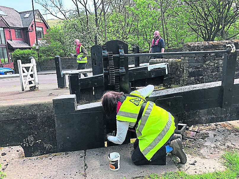 Painting the gates at Wade Lock on the Huddersfield Narrow Canal. PHOTOS: UCAN