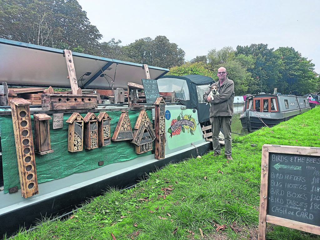 Richard Paterson and his dog Harvey beside his narrowboat Smoke on the Water.