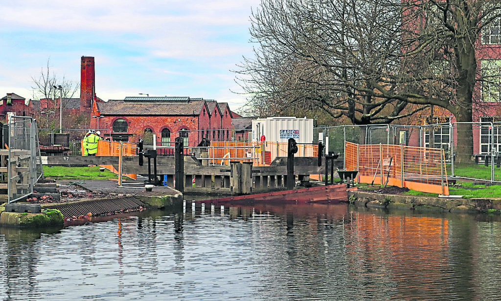 Stop planks and the safety fencing going into place around lock 87 on the Leeds & Liverpool canal in Wigan. The work to reduce water loss through the bottom gates is being carried out as part of the winter stoppage programme. This lock is the bottom one of the flight of locks that come down from Aspull above Wigan.