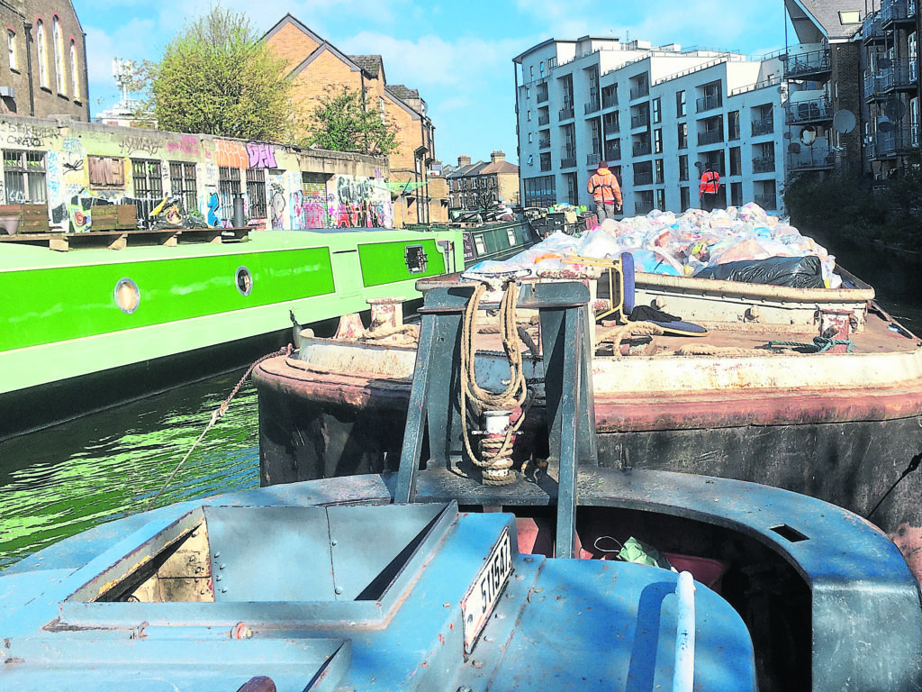 Manoeuvring tug and ‘tow’ past moored boats on the GU Paddington Arm.