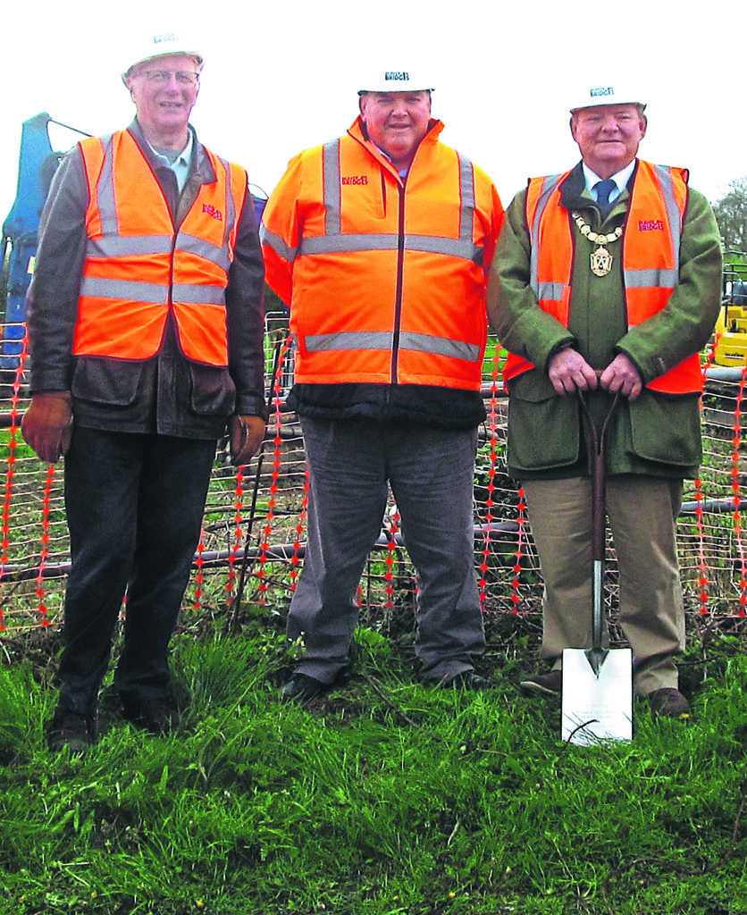 Coun Vince Hunt prepares to cut the first sod with, from left, Michael Limbrey, chairman of the Restore the Montgomery Canal! group and Don Howell of Beaver Bridges.