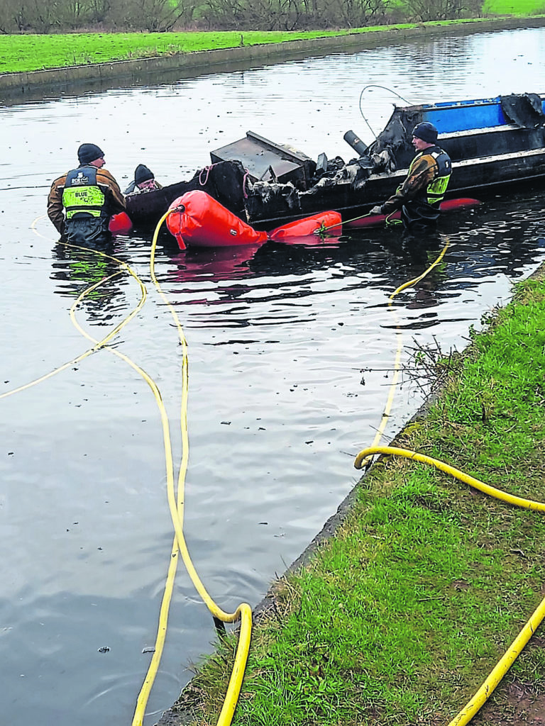 A River Canal Rescue team recovers a burnt-out boat.PHOTO: RCR