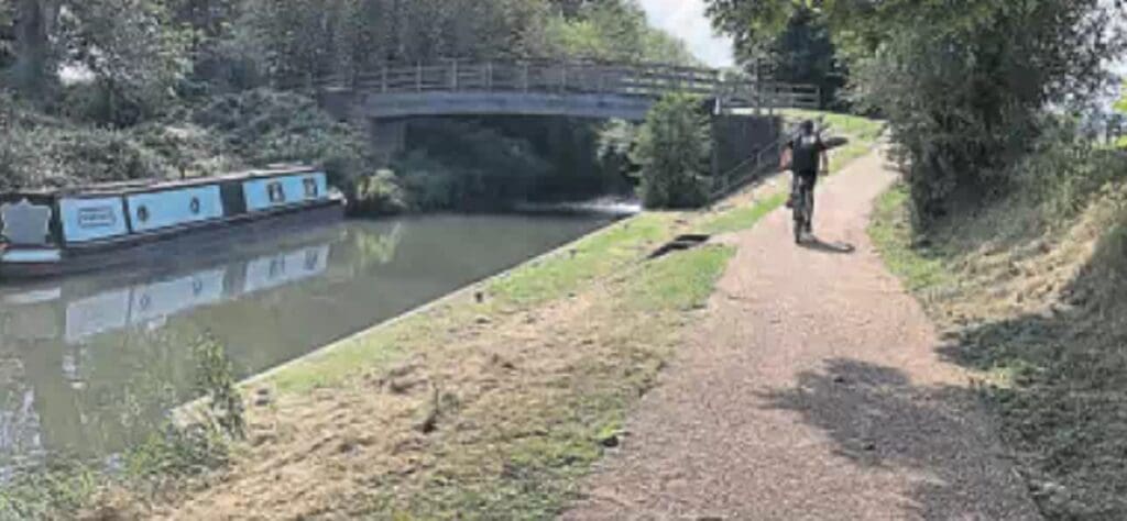 A cyclist on the upgraded towpath approaching Towney, Lock 97 on the Kennet & Avon Canal.