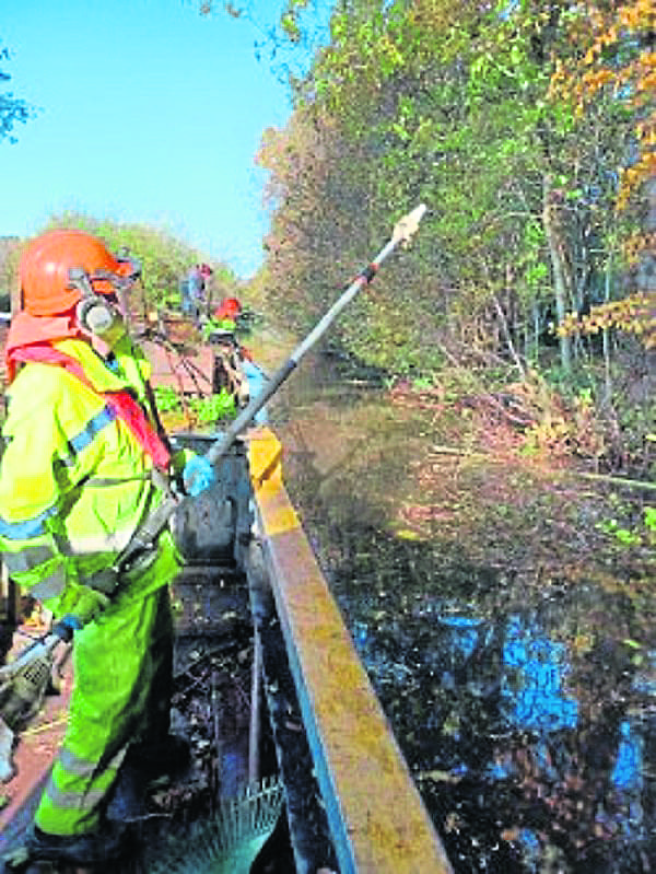 Tackling offside vegetation from the workboat. PHOTOS: NEIL BARNETT