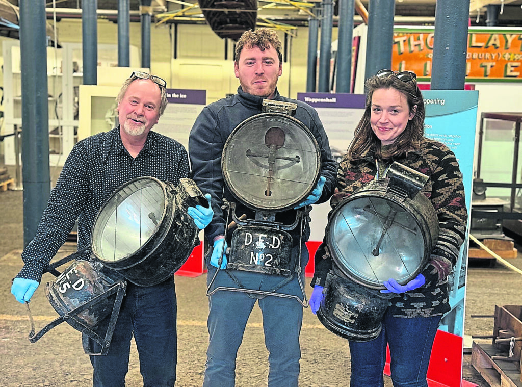 The National Waterways Museum team, from left: Steve Bagley, manager of National Collections; Alec Swain, collections technician; Georgina Wilson-Williams, collections technician with the recovered Tilley lamps. PHOTO: CANAL & RIVER TRUST