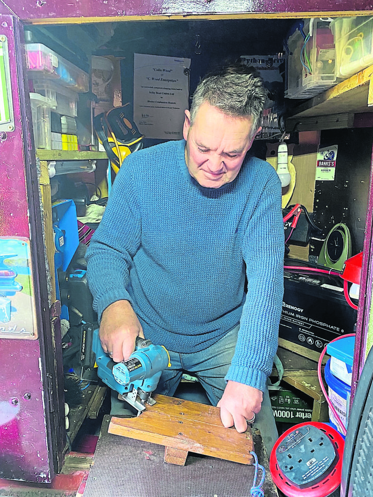 Man cave: Colin at work in his onboard workshop.